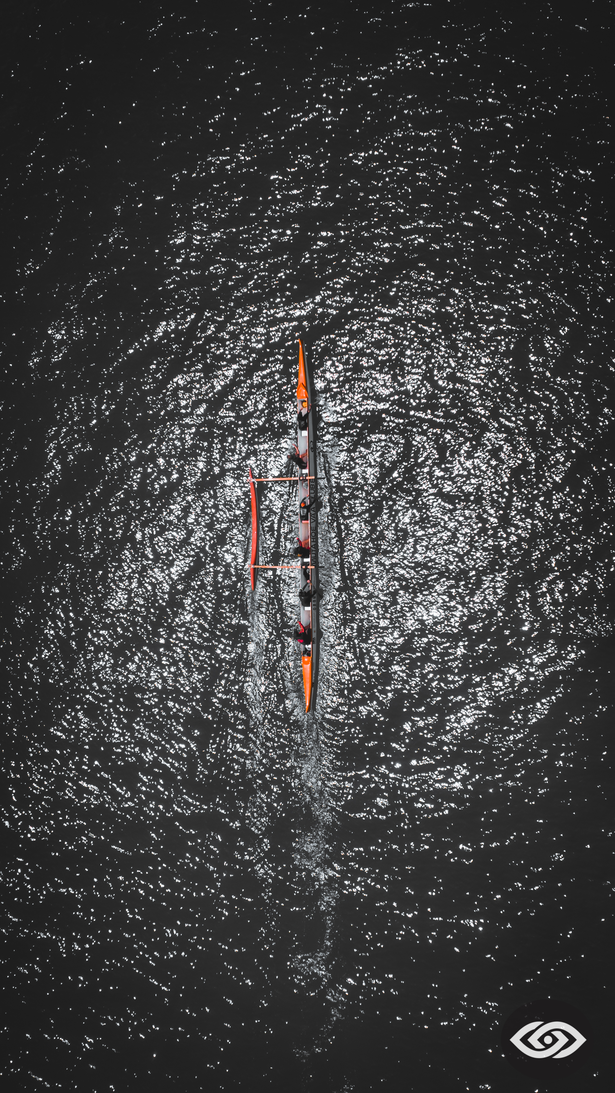 Vista aérea noturna da canoa havaiana refletindo luzes na água