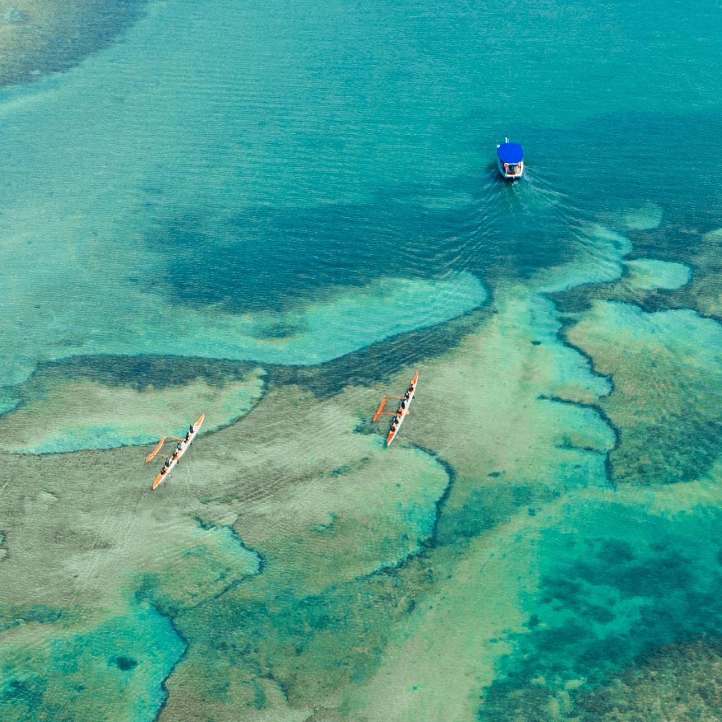 Vista aérea de canoas havaianas remando sobre recifes de Barra Grande