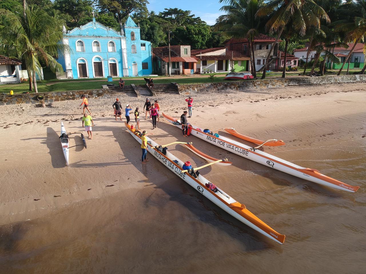 Canoas na praia em frente à igreja histórica de Boipeba